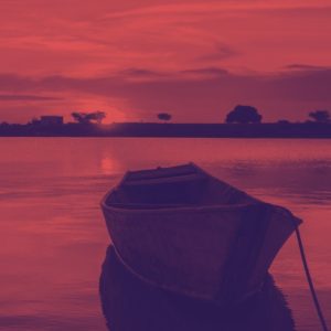 A boat rests atop a body of water. There a pink/reddish overlay atop the entire image.